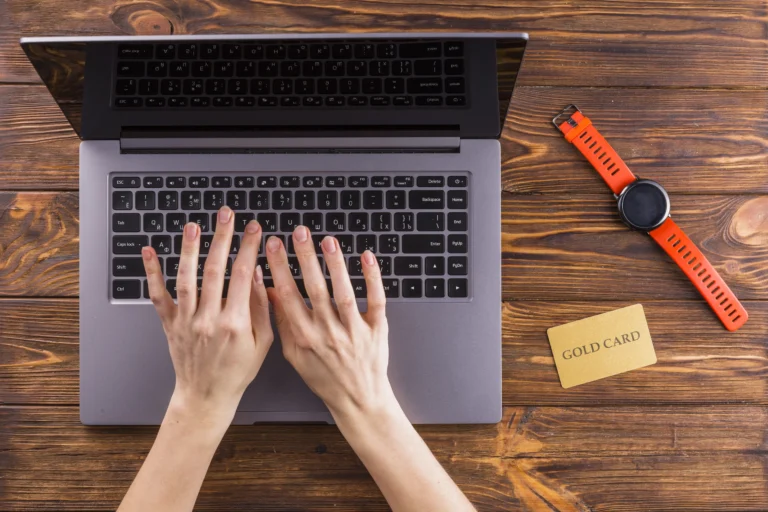 Elevated view hand typing laptop wooden table (1)